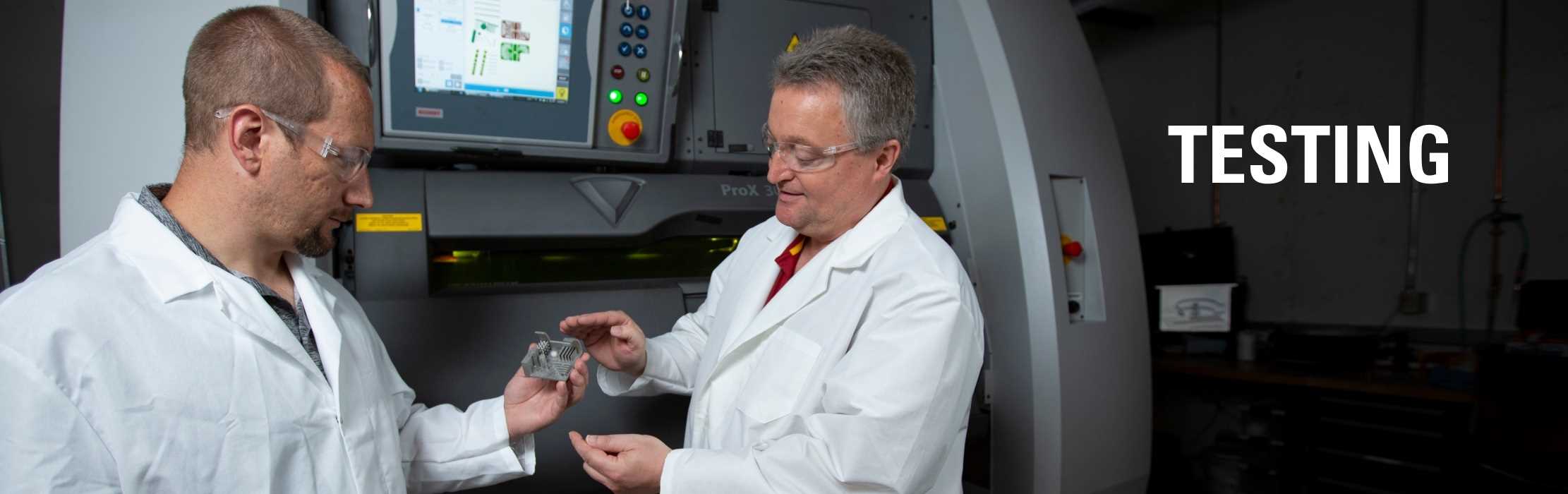 Two engineers examining a product manufactured with a metal additive manufacturing machine: Testing.