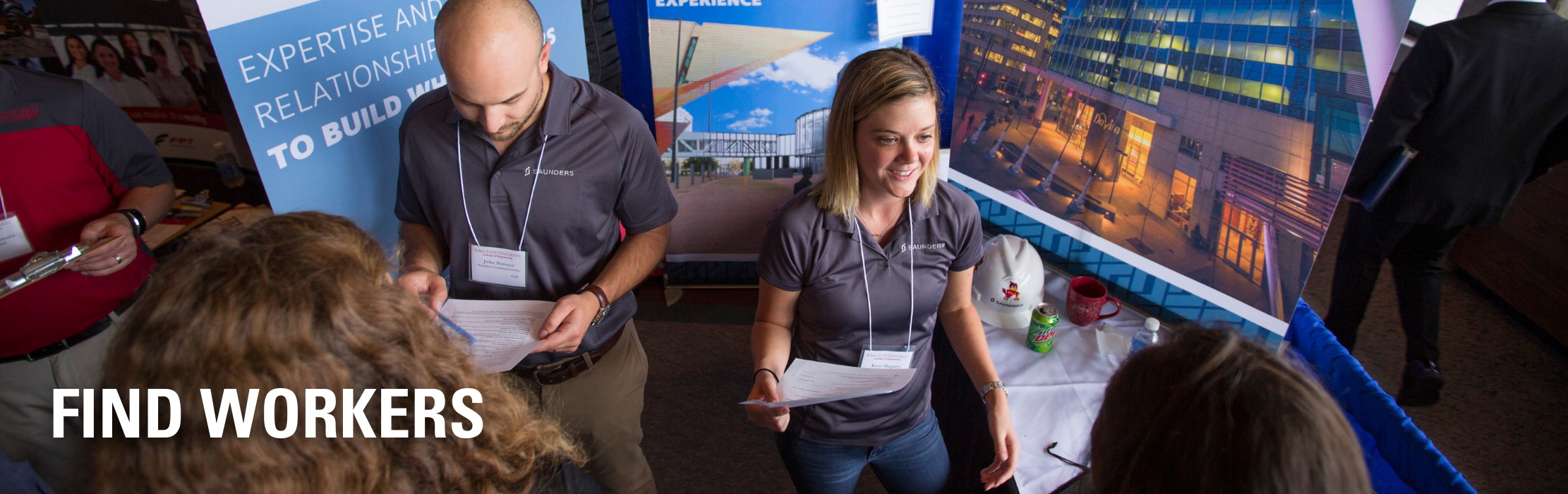 People staffing a booth at a job fair.