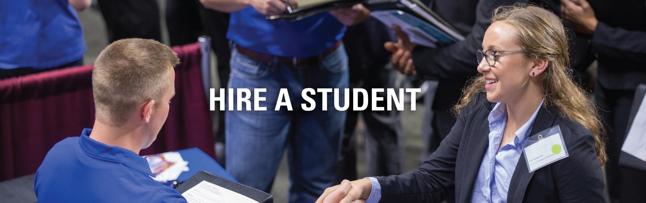 Company recruiter greeting an engineering student at the Iowa State University engineering career fair.