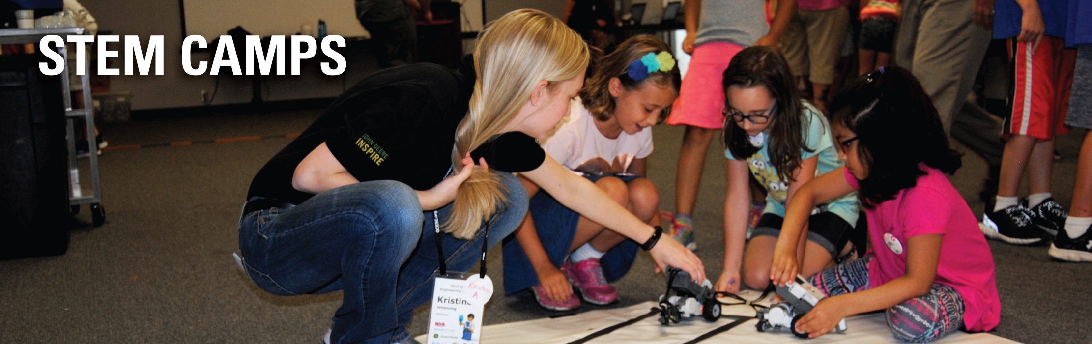 Industry engineer mentoring young girls at an ISU STEM camp.